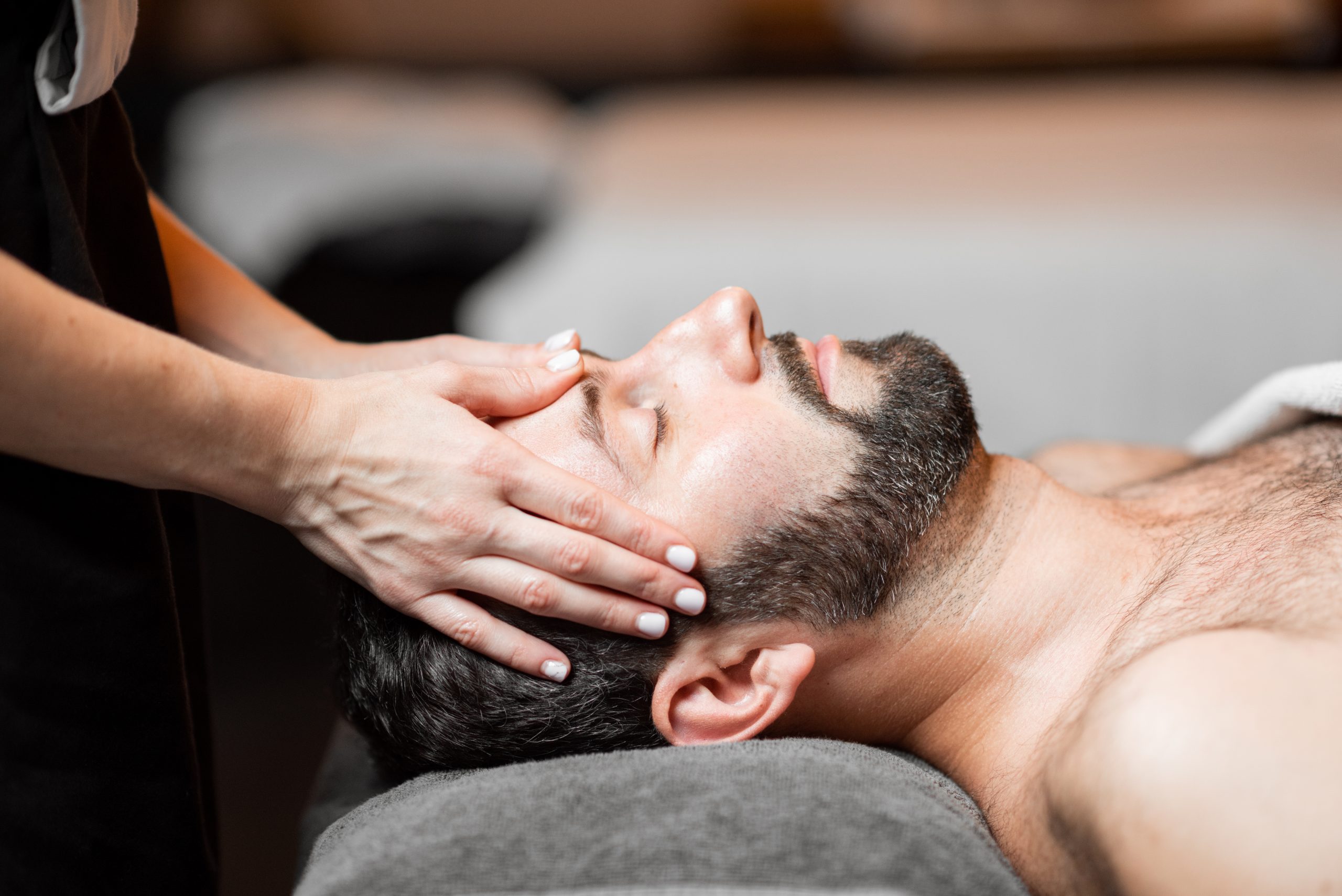Man receiving facial massage at Spa salon